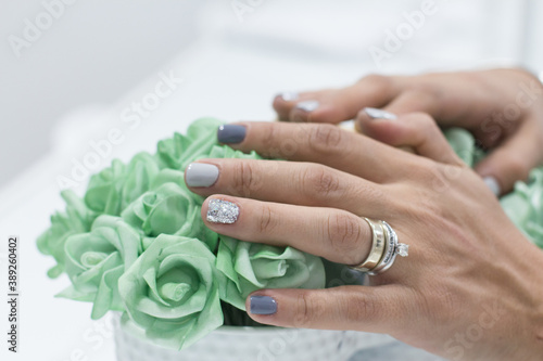 Mujer joven adolescente haciéndose manicure en un salón de belleza. Uñas con gelish barniz azules.  photo