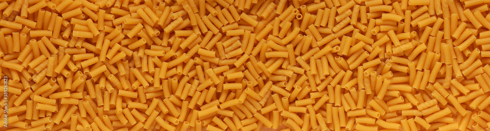 Background. Raw macaroni. The view from the top. Meal. The view from the top. At close range. Panorama. Foodstuff. Background. Raw macaroni. The view from the top. Meal. The view from the top. At close range. Panorama. Foodstuff.