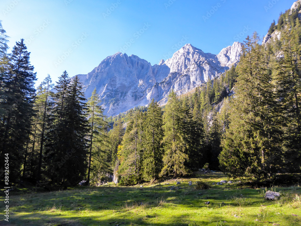 A panoramic view on a massive, stony mountains in Hochzin?dl region, Austrian Alps. There are endless mountains chains in the back. The slopes are overgrown with moss and grass. Sunny and bright day.