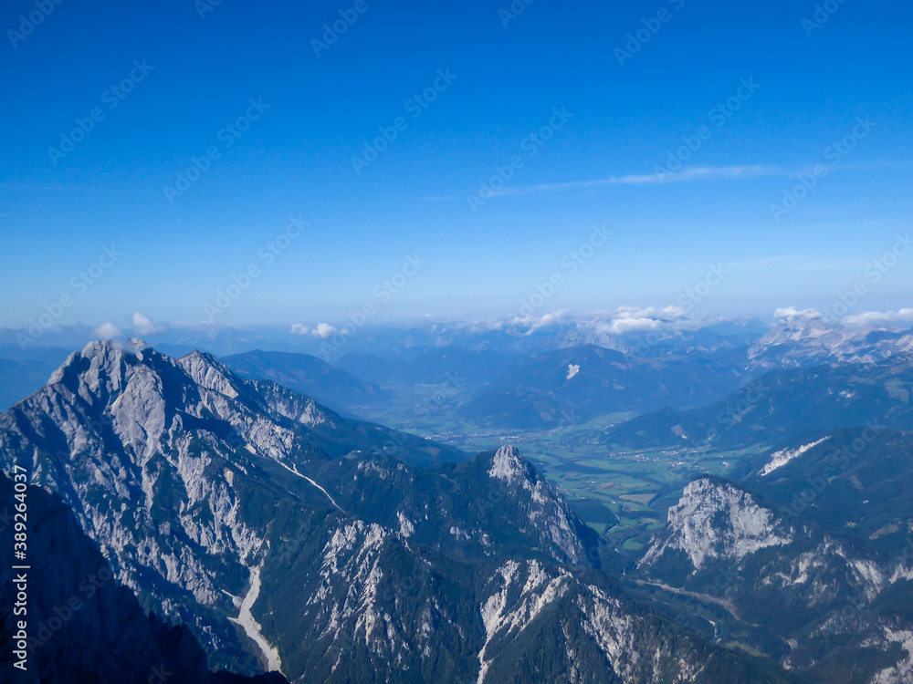 A panoramic view on endless mountain chains from top of a mountain in Hochtor region, Austrian Alps. High Alpine mountaineering. Sunny, cloudless summer day. Exploring new places.