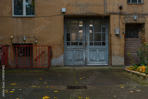 Canvas Print Weathered facade of a house, gate of a house passage, unrenovated house in Berli