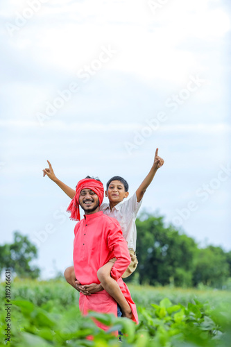 Indian farmer playing with his child at green field