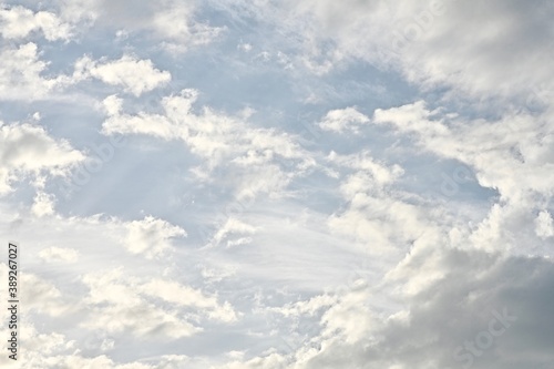 Light blue sky with light gray and white clouds in diffused light