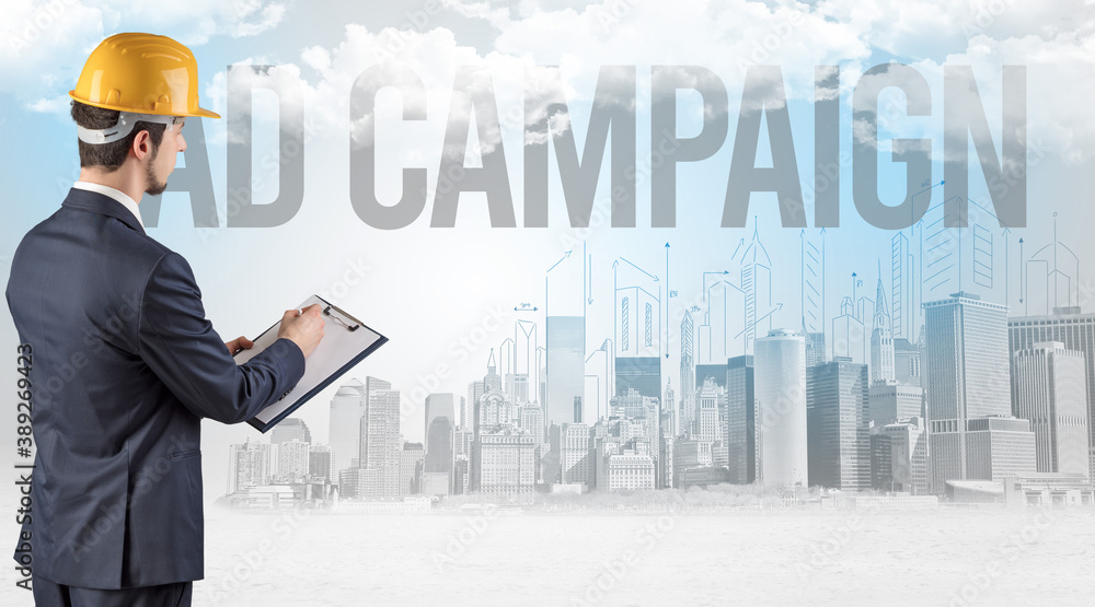 Young businessman with hard hat and AD CAMPAIGN inscription, new business opportunity concept Young businessman with hard hat and AD CAMPAIGN inscription, new business opportunity concept