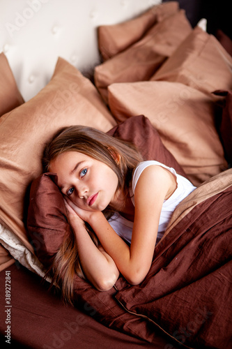 Fotografi cute girl lies in a huge bed