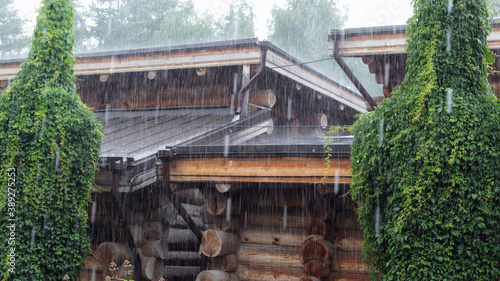Heavy rain over wooden houses with greenery