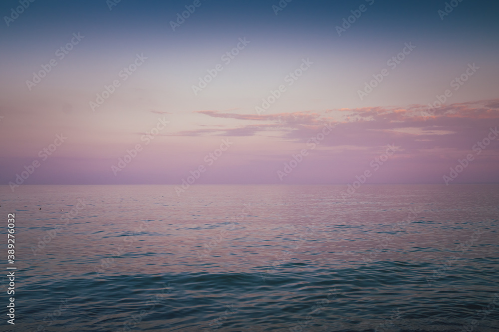 Obraz premium Sky in the pink, blue and purple colors sky at sunset. Blue hour after sunset on the sea. Beautiful clouds on the horizon