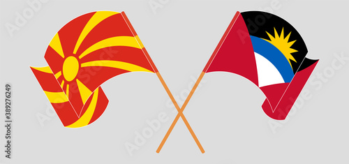 Crossed and waving flags of Antigua and Barbuda and North Macedonia