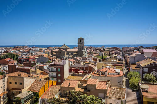 View over the roofs of old town Malgrat de Mar (Spain) from the hill with Mediterranean sea in the background and the Cathedral of the Coast in the middle photo