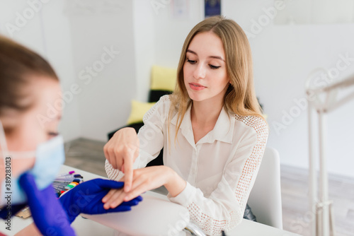 Female manicure master in a beauty salon work with hands of the client