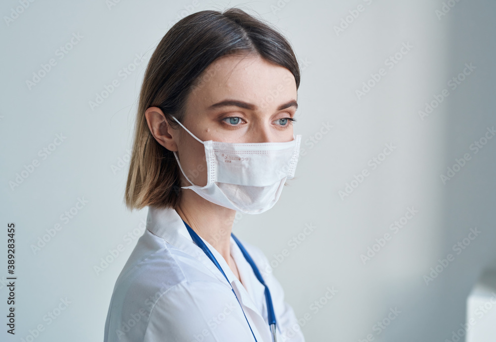 Woman nurse in medical mask blue stethoscope light background Woman nurse in medical mask blue stethoscope light background