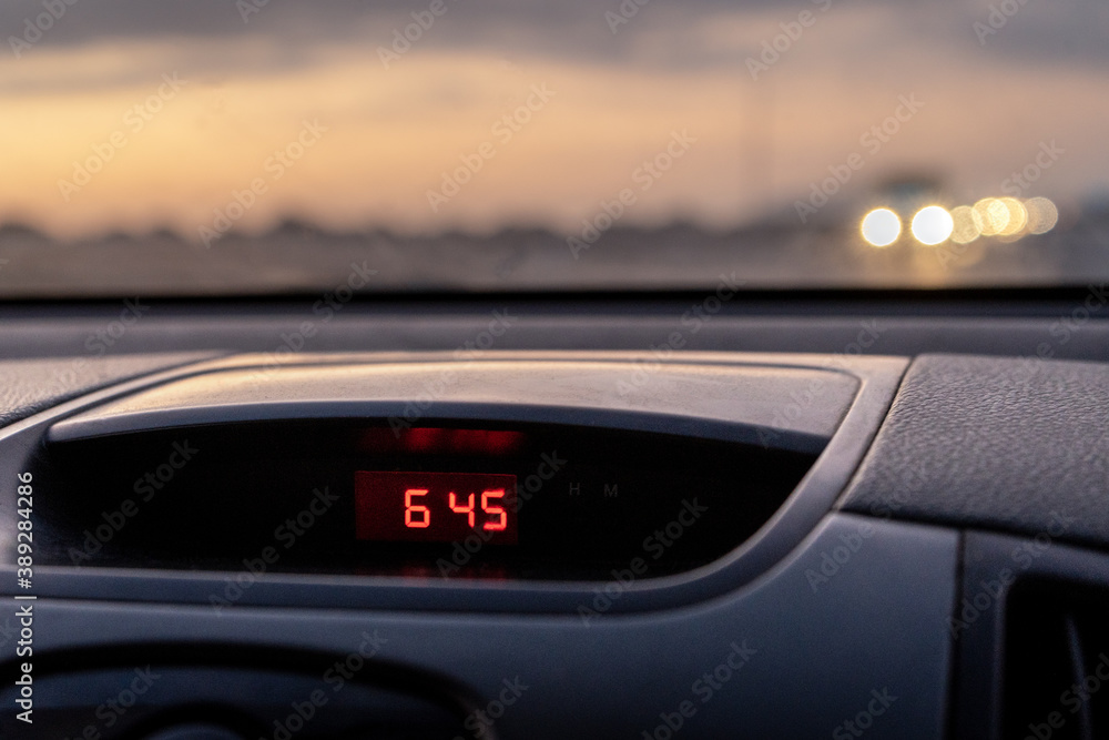 Car sets the time on the road 6:45. bokeh on the road. Sunset.
