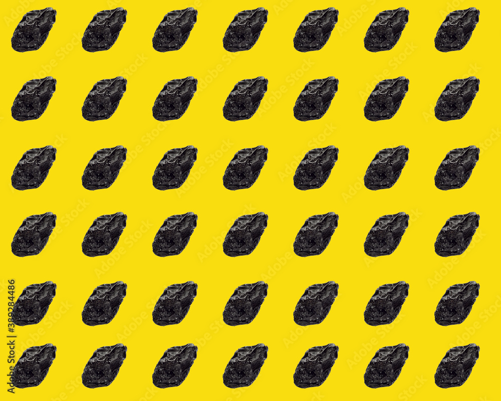 Black prunes on a yellow background many fruits Black prunes on a yellow background many fruits