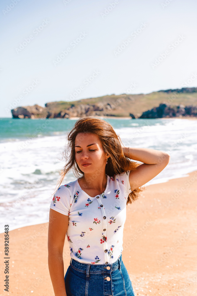 Beautiful young woman with long hair walks along the Black sea on the beach Beautiful young woman with long hair walks along the Black sea on the beach