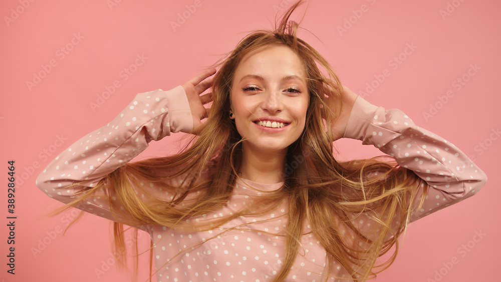 Young beautiful caucasian brunette dancing on pink background. High quality photo