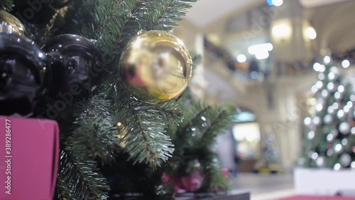 A Christmas tree decorated with Golden and black balloons stands in the lobby of the shopping center