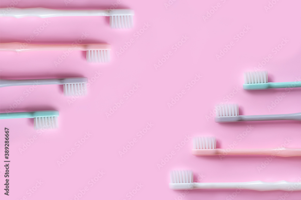 toothbrush in pastel colors on pink background .copy  space  flat lay .