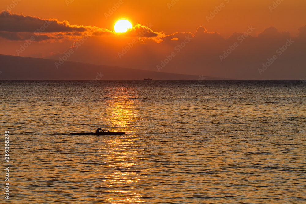 Lone kayaker rowing quickly across the ocean on Maui.