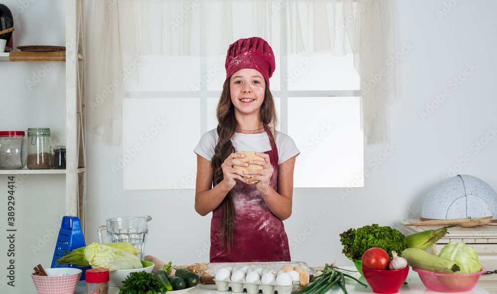 small girl baking in kitchen. kid chef cooking making dough. child prepare healthy food at home and wearing cook uniform. housekeeping and home helping. childhood development. professional chef small girl baking in kitchen. kid chef cooking making dough. child prepare healthy food at home and wearing cook uniform. housekeeping and home helping. childhood development. professional chef