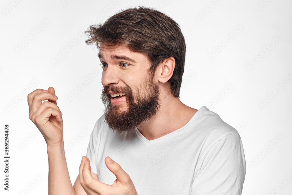 cheerful emotional bearded man gesturing with his hands close-up light background cheerful emotional bearded man gesturing with his hands close-up light background