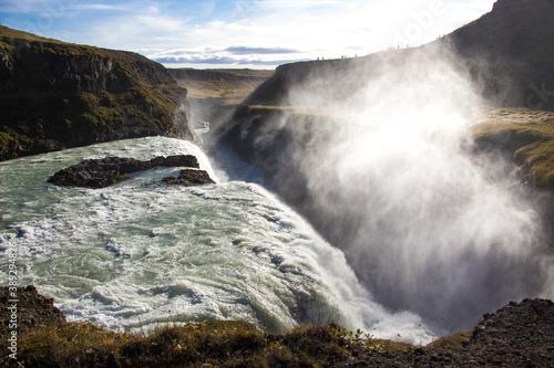 GULLFOSS, ICELAND, SEPTEMBER 19, 2018: Mist rising from famous waterfall located in the canyon of the Hvítá river in southwest Iceland. Sunny day during autumn.