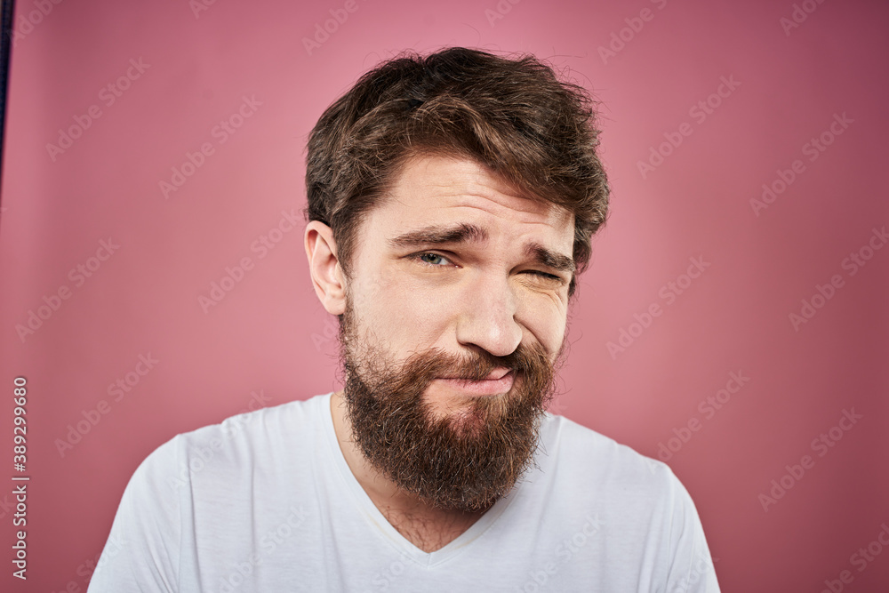 Fototapeta premium bearded man in white t-shirt emotions displeased facial expression studio pink background