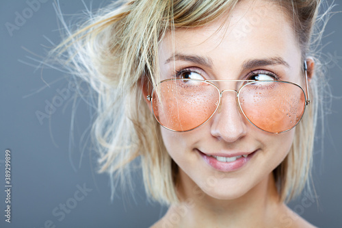 Beautiful girl fashion portrait. Wearing wet glasses with water drops visible.