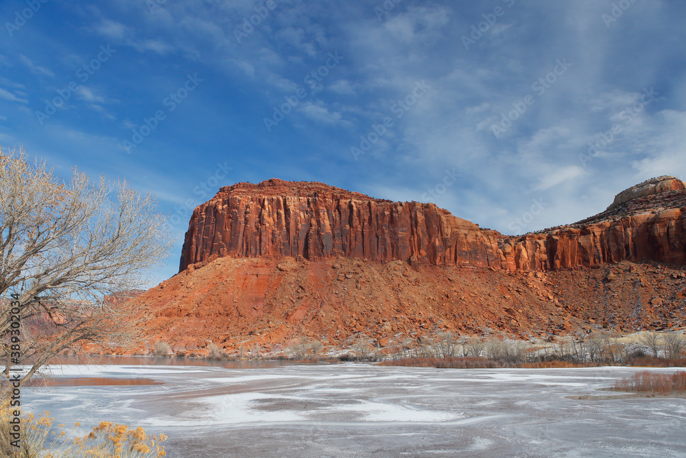 Traditional southwest landscape with red sandstone mountains with frozen river in foreground, USA, Arizona, Utah.