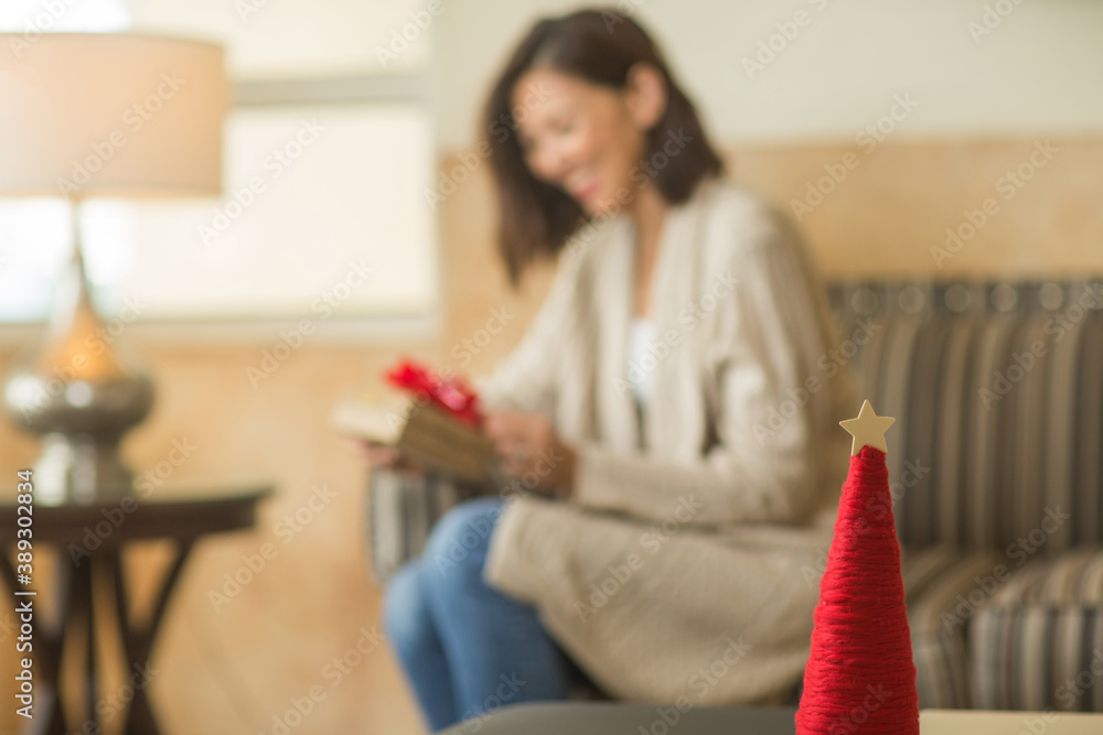 Asian woman holding a gift sitting on the sofa. Asian woman holding a gift sitting on the sofa.