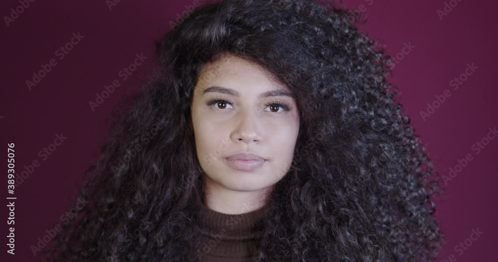 Beautiful curly hair woman standing over red background with open hand doing stop sign with serious and confident expression, defense gesture. No more violence against women. Abuse. 4K. Beautiful curly hair woman standing over red background with open hand doing stop sign with serious and confident expression, defense gesture. No more violence against women. Abuse. 4K.
