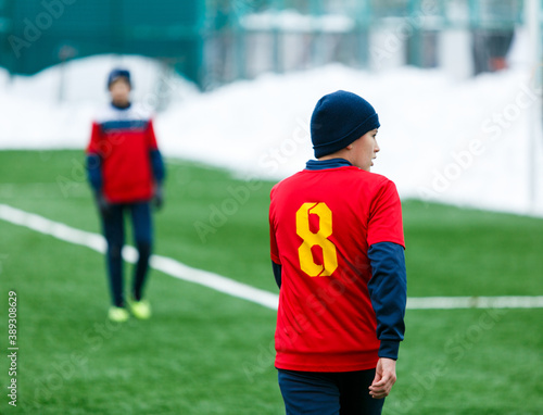 Boy in red uniform playing football