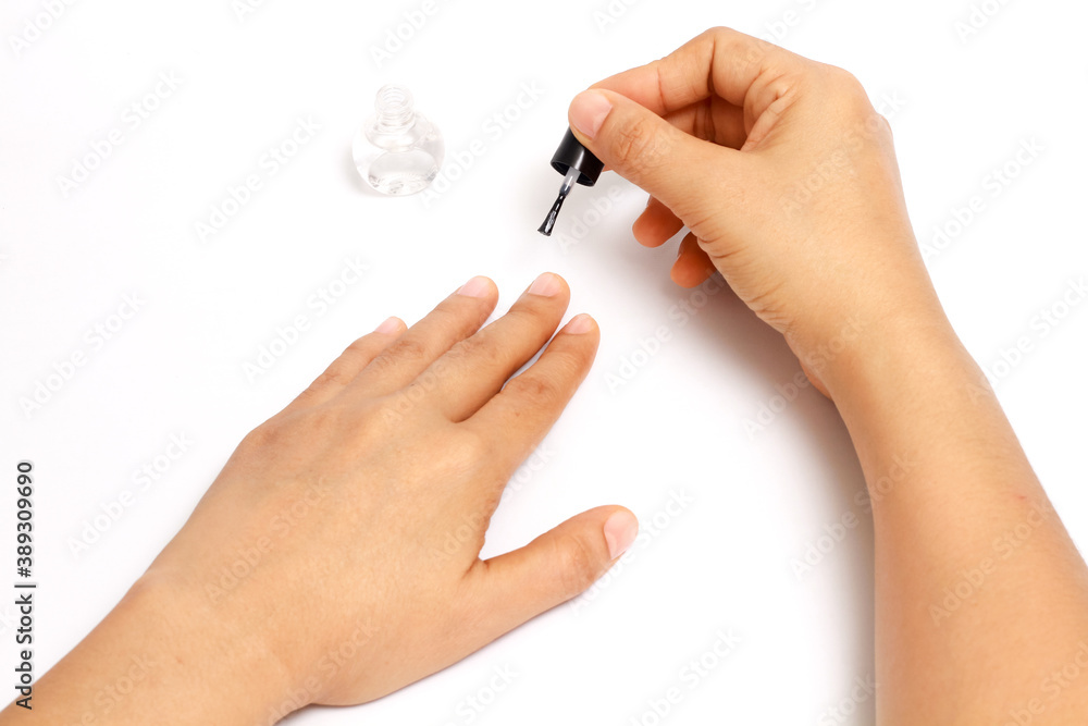 manicure applying, brushing fingernails with clear enamel, nail painting transparent nail polish on white background manicure applying, brushing fingernails with clear enamel, nail painting transparent nail polish on white background