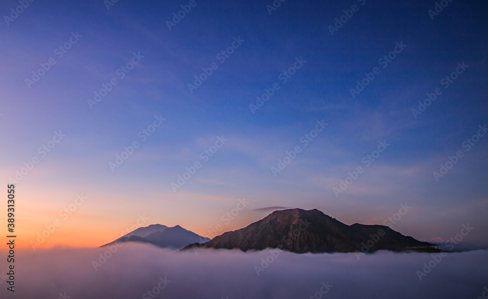 Batur Mountain in Kintamani, Bali Island Indonesia in the morning with blue sky and orange sky 