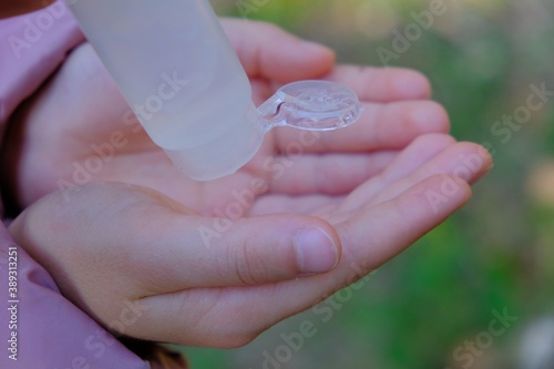 little girl sanitizing her hands