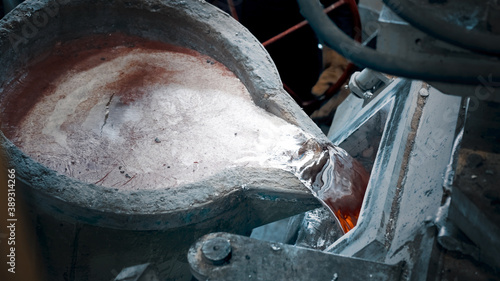 Fotografie Ladle with molten metal is poured into a mold