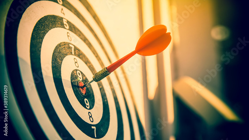 Photos Bulls eye or dart board has red dart arrow throw hitting the center of a shooting target for business targeting and winning goals business concepts