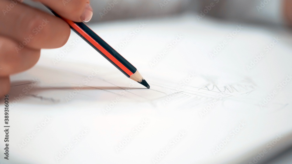 Girl with white nails draws a sketch on paper Girl with white nails draws a sketch on paper