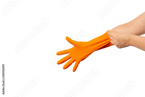 Women's hands putting on the protective orange rubber gloves isolated on white background