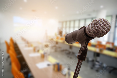 Blurred background of conference hall or seminar room with Microphone.