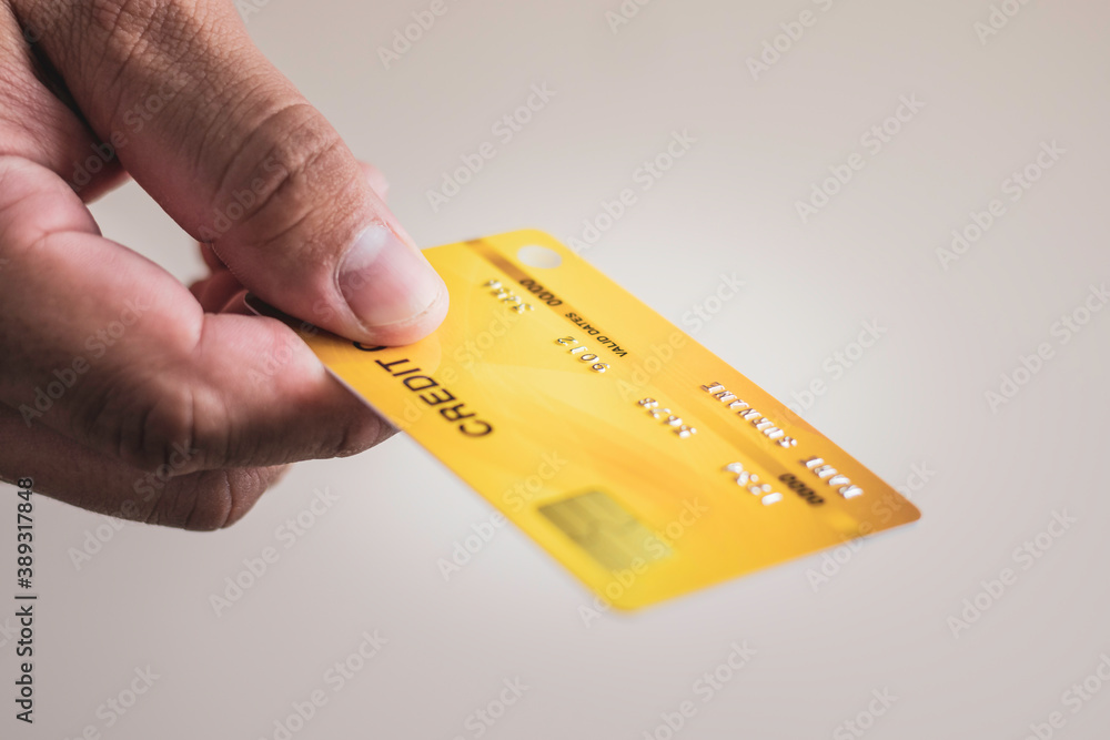 A man hand holding gold credit card, financial business and online marketing concept, shopping credit card payments A man hand holding gold credit card, financial business and online marketing concept, shopping credit card payments