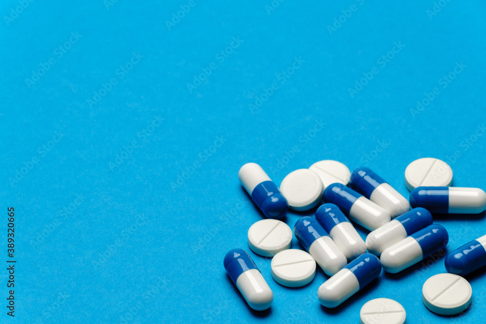group of pills or capsules on blue background group of pills or capsules on blue background