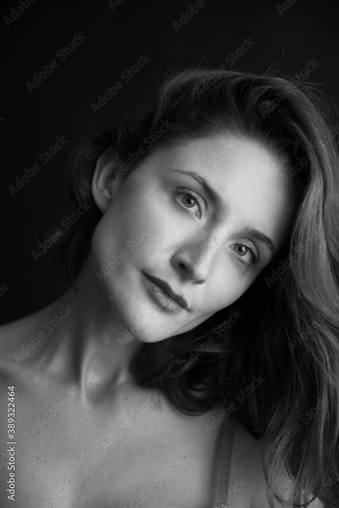black and white portrait of a young girl on a dark background in the Studio black and white portrait of a young girl on a dark background in the Studio