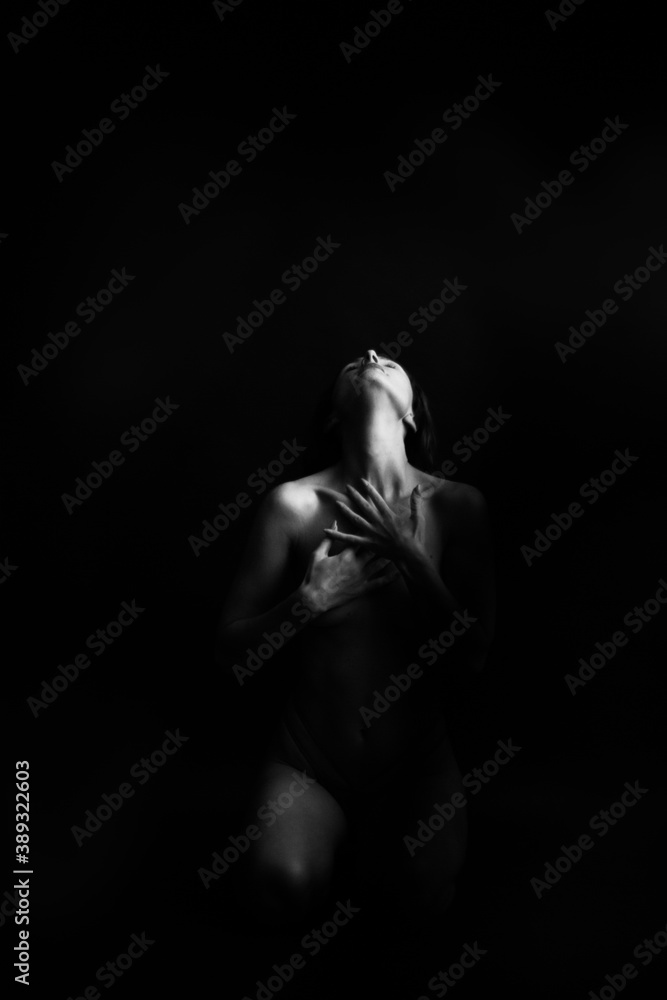 Obraz premium black and white portrait of a young girl on a dark background in the Studio