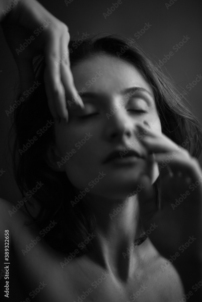 black and white portrait of a young girl on a dark background in the Studio black and white portrait of a young girl on a dark background in the Studio