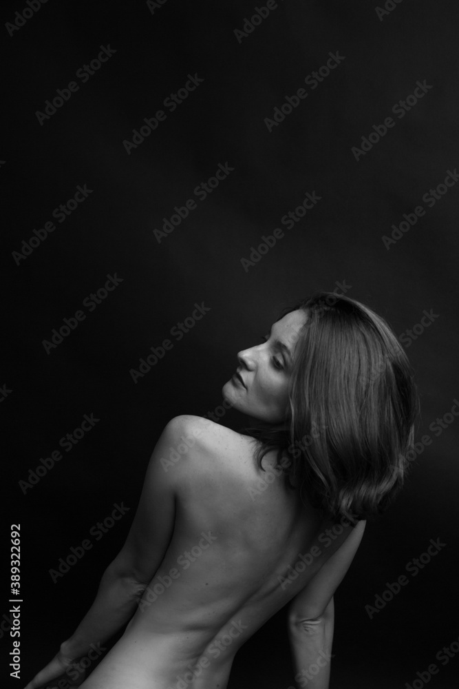 black and white portrait of a young girl on a dark background in the Studio black and white portrait of a young girl on a dark background in the Studio