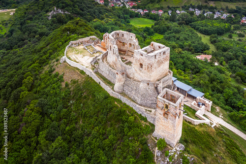 Csesznek, Hungary - Aerial view of the hilltop Castle of Csesznek and Csesznek city at sunset on a sunny summer afternoon with green trees photo