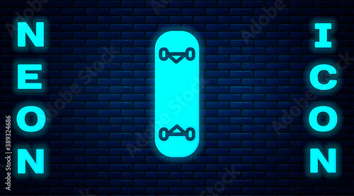Glowing neon Skateboard trick icon isolated on brick wall background. Extreme sport. Sport equipment. Vector Illustration.