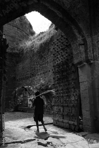 broom seller isolated in Kalaburagi fort back entrance gate in monochrome photo photo