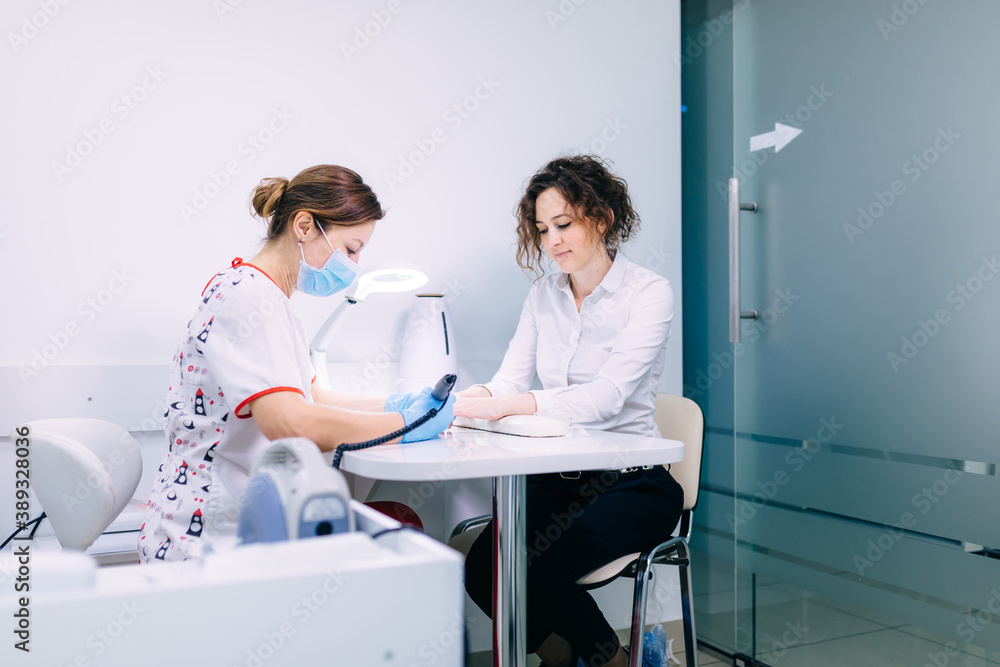 Manicure procedure in progress - Beautician master using nail dr Manicure procedure in progress - Beautician master using nail dr