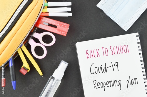 Back to school COVID-19 reopening plan, flat lay arrangement of school supplies and personal protective equipment. Education concept due to Coronavirus COVID-19 pendemic. photo